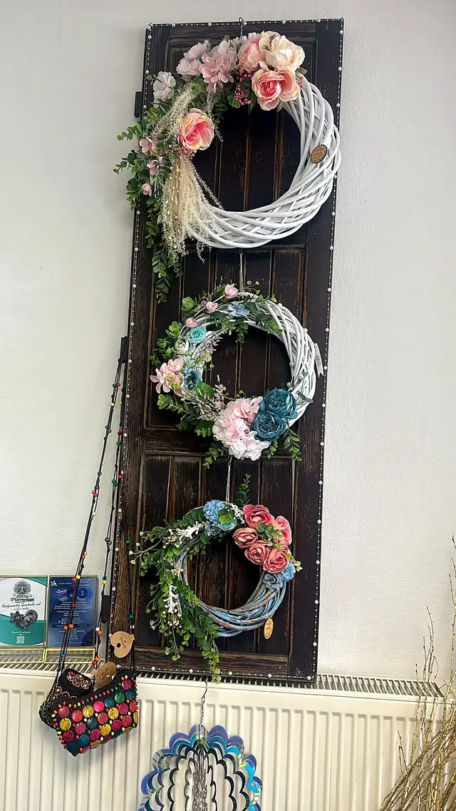 Drei handgebundene Türkränze mit Blumen in Rosa, Blau und Grün